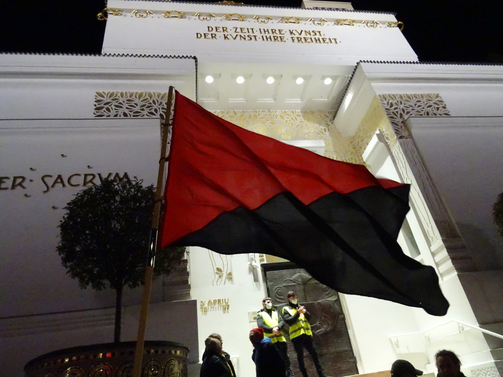 Schwarz-rote Fahne weht vor dem Jugenstil-Gebäude der Wiener Secession mit der Inschrift: "Der Zeit ihre Kunst, der Kunst ihre Freiheit" über dem Eingangsportal, das von Sicherheitskräften bewacht wird.